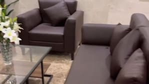 A modern living room with a brown leather sofa, a matching armchair, and a glass coffee table. - Al Tawfeeg Hotel Azizyah (Makkah)
