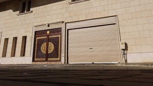 A multi-story building with a beige facade, multiple windows, and a large decorative gate at the entrance. - Al Tawfeeg Hotel Azizyah (Makkah)