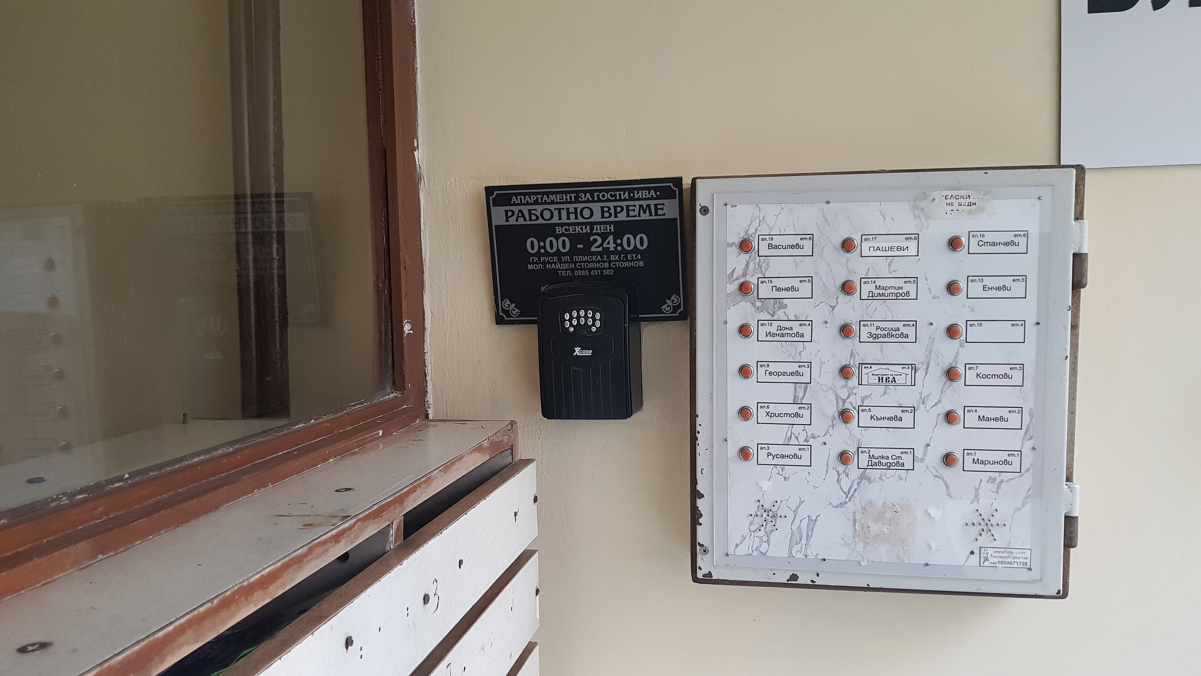 Un sistema de intercomunicación instalado en la pared, con un cartel que indica acceso las 24 horas y un directorio con números y nombres de habitaciones.