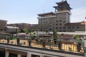 A hotel with a traditional architectural style, featuring a prominent tower and multiple windows.