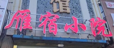 A hotel sign with large, bold characters and a reflective glass window below.