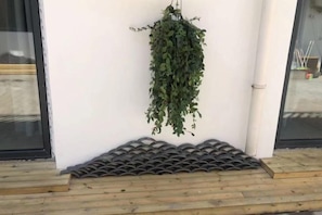 A hanging plant, a tiled ledge, and a wooden deck. - Baiyangdian Weinan Hotel (Anxin)
