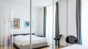Una habitación de hotel moderna con cama, mesita de noche y una silla.