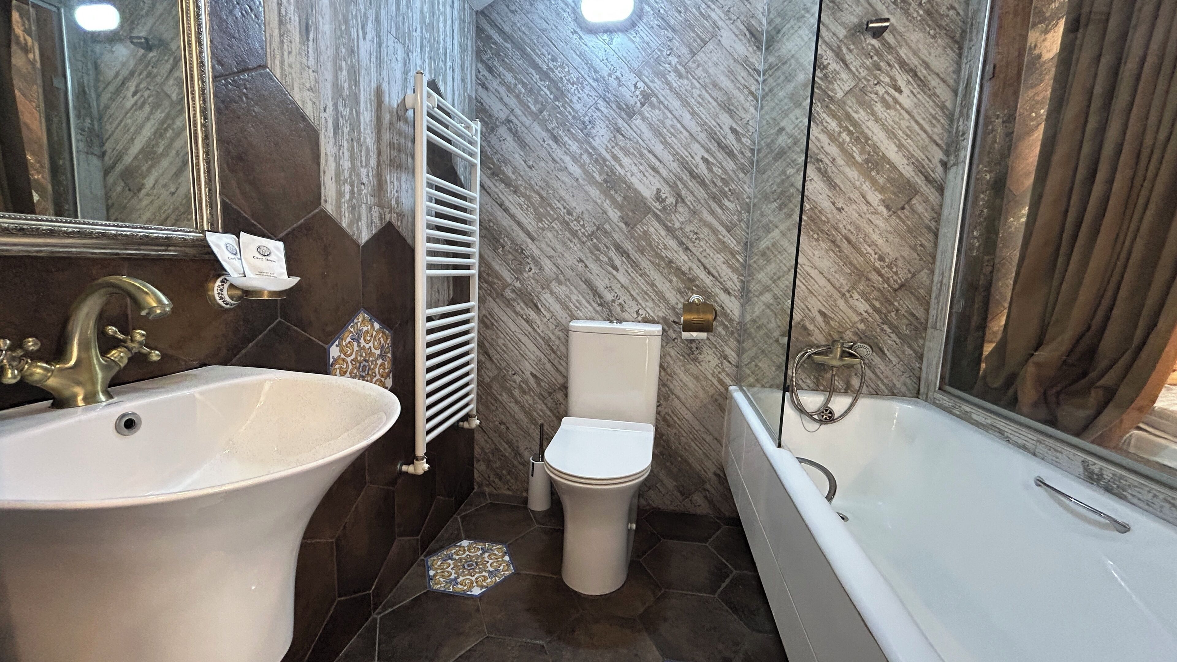 Een badkamer met een groot wastafel, toilet en bad.