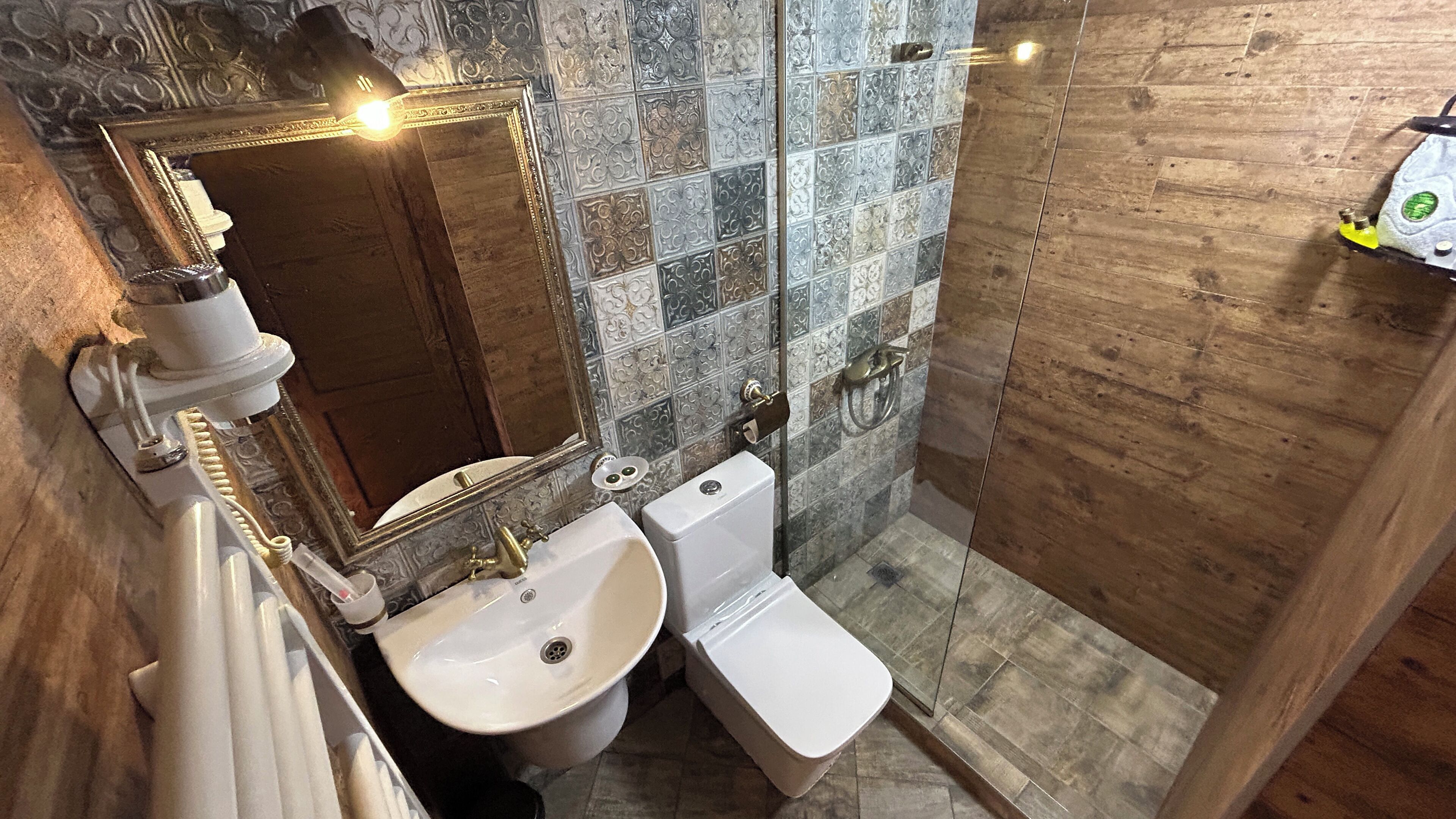 Un baño con lavamanos, inodoro y espejo.