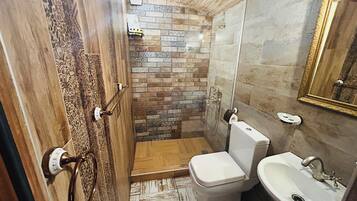 A bathroom with a shower, toilet, and sink.