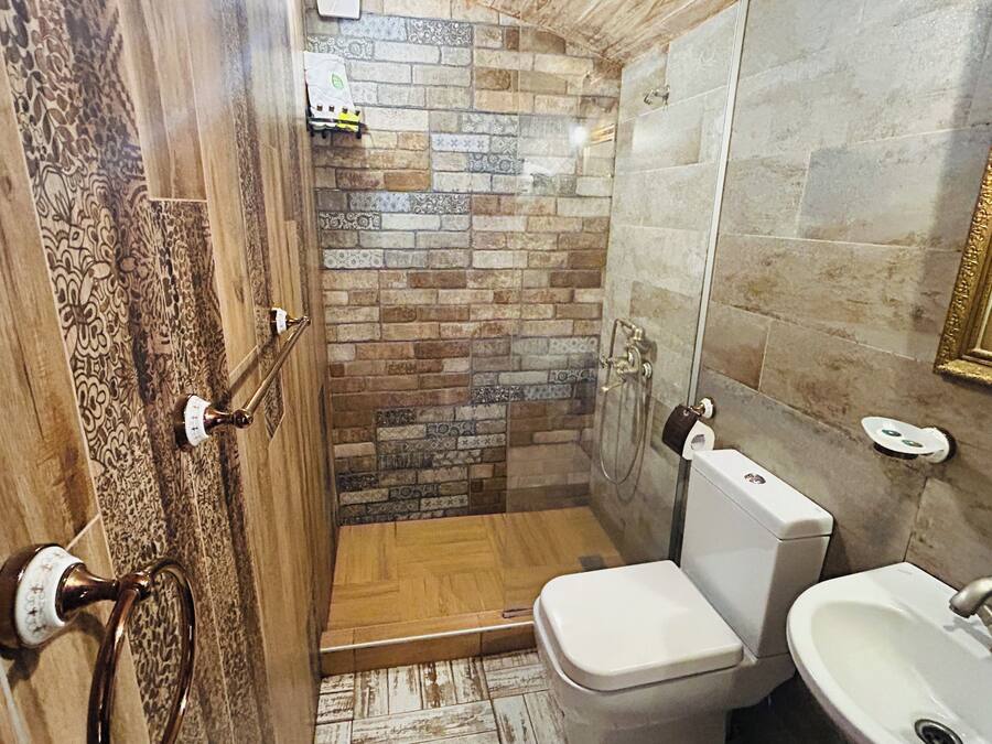A bathroom with a shower, toilet, and sink.