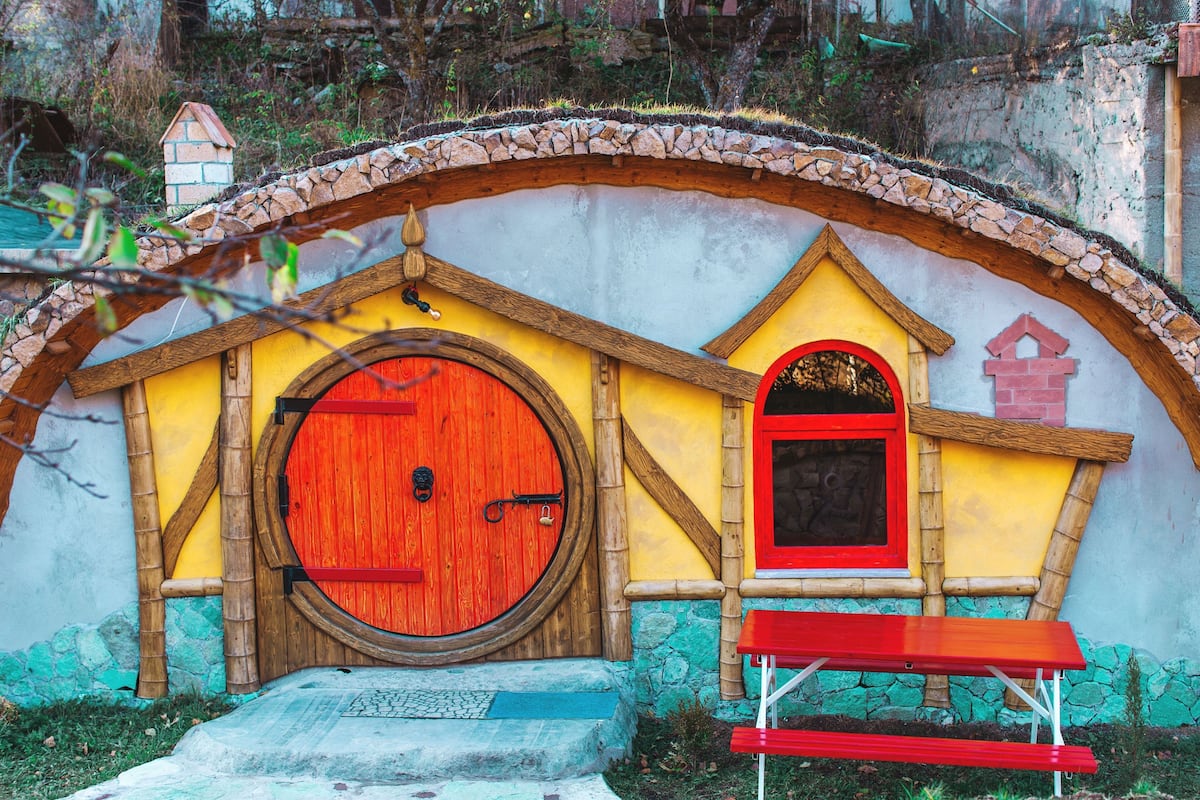 A colorful building with a large wooden door and a small window.