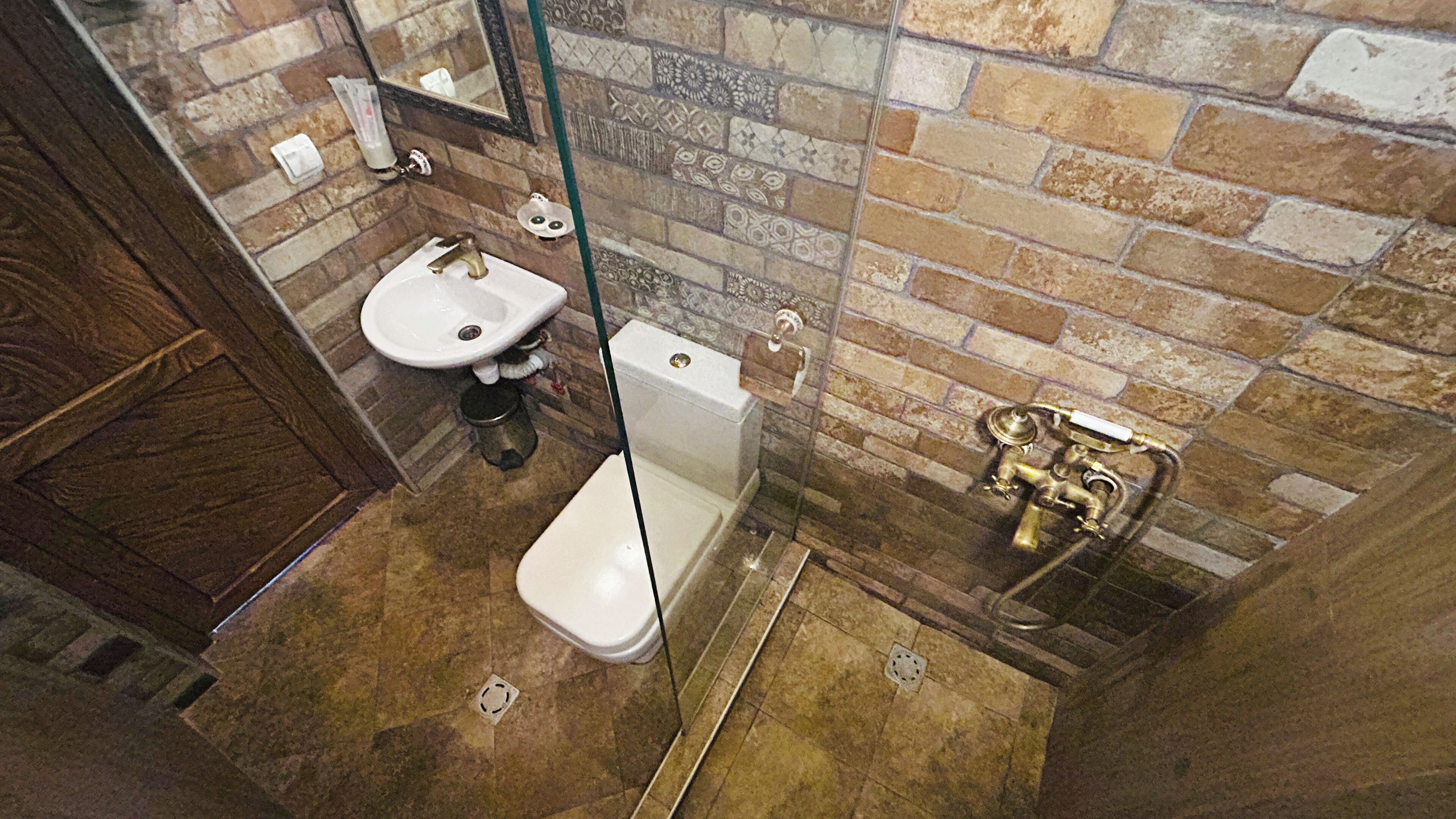 A bathroom with a white sink, a toilet, and a shower area with a glass door.