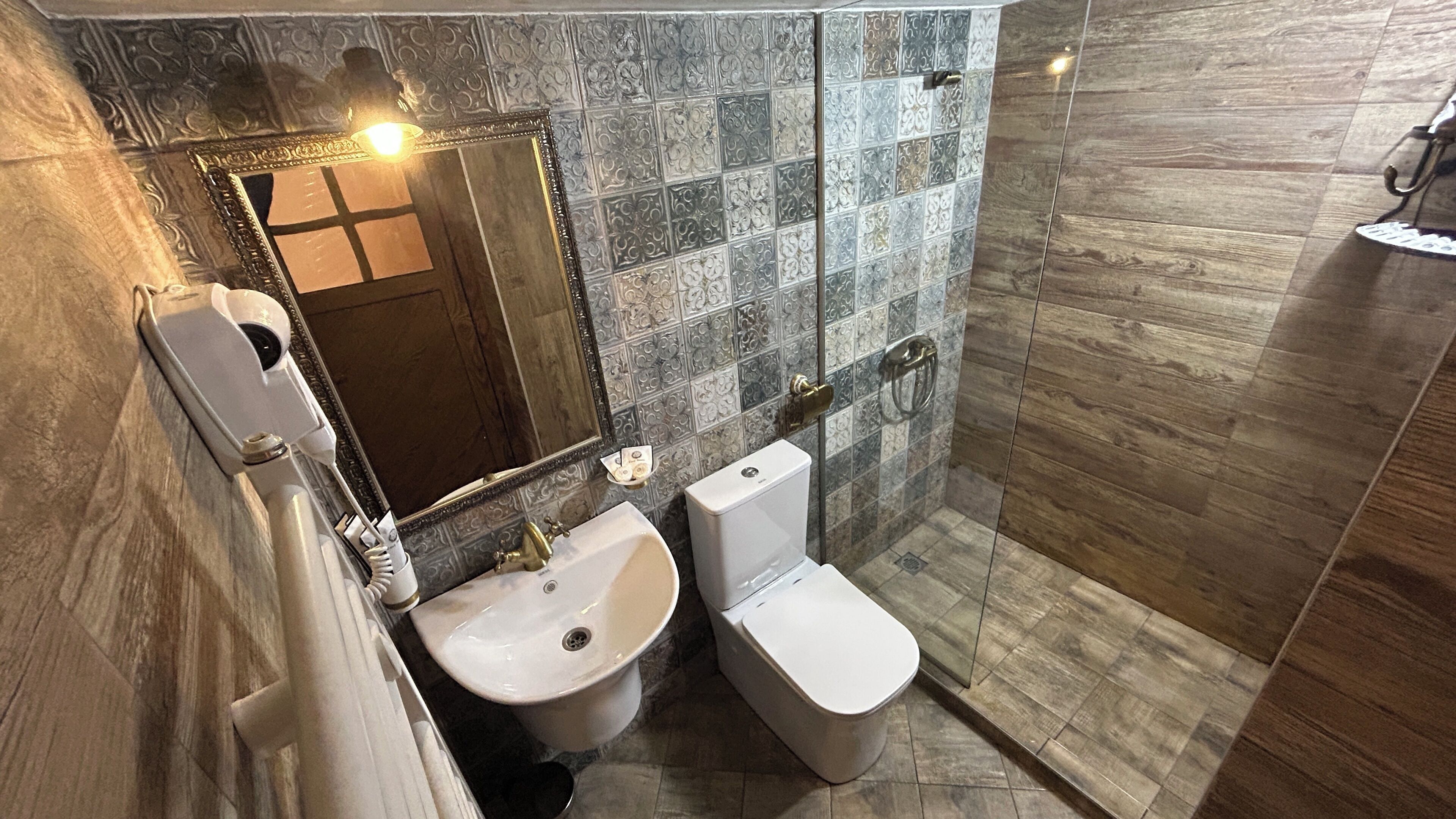 A bathroom with a sink, toilet, and a mirror.