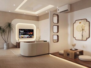 Un salon moderne avec un canapé aux lignes courbes, un téléviseur fixé au mur diffusant une émission et une décoration minimaliste agrémentée d’un miroir mural et d’œuvres d’art.