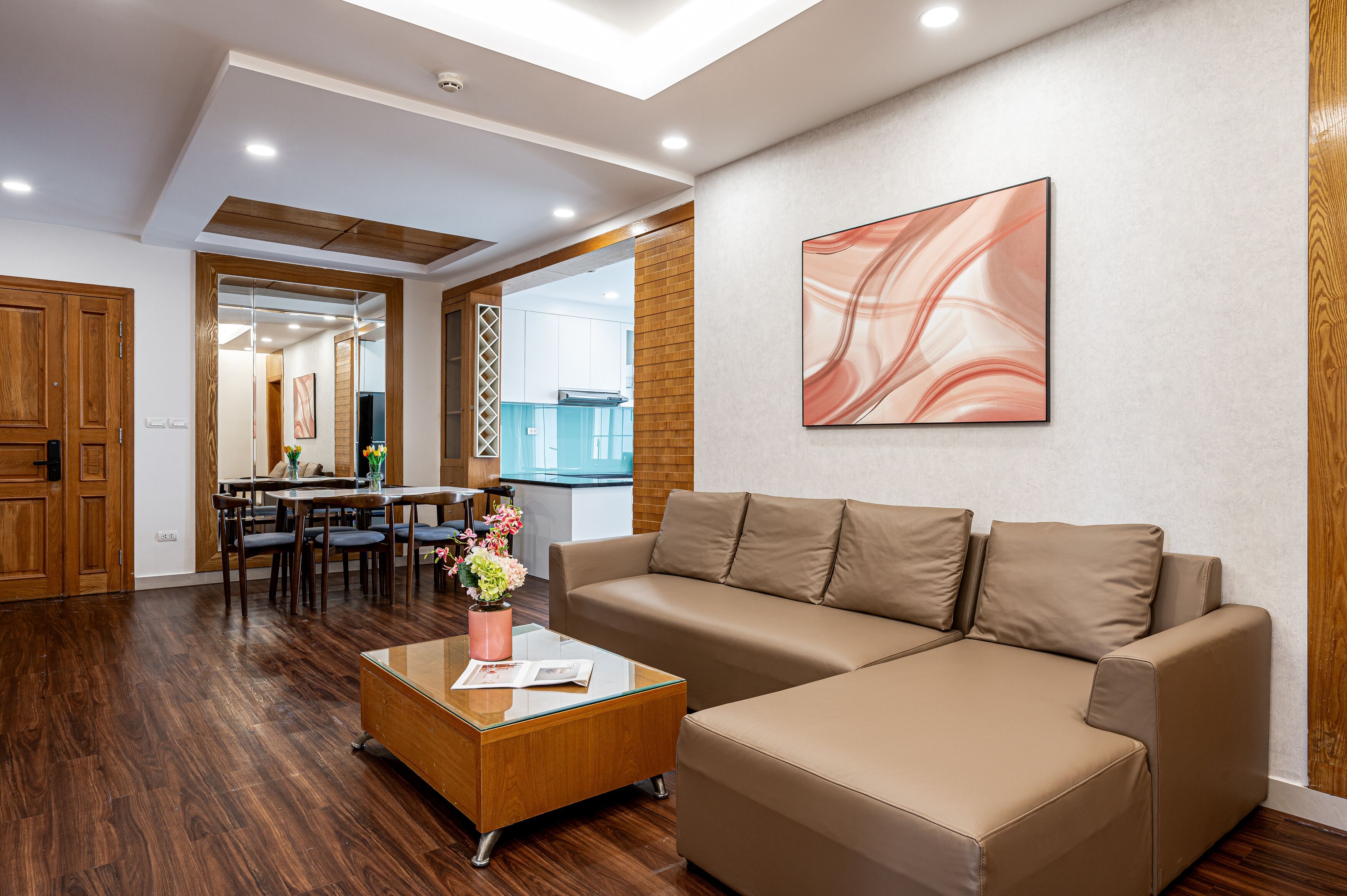 A modern living room with a sofa, coffee table, and dining area.
