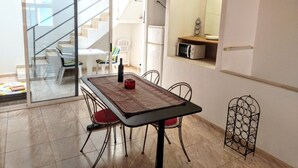 A dining area with a table, chairs, and a kitchen area with a microwave. - Arguineguin, vacation home directly by the sea, Casa Perchel (Arguineguin)