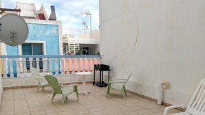A terrace with tiled flooring, a white wall, and a railing with blue and pink accents. - Arguineguin, vacation home directly by the sea, Casa Perchel (Arguineguin)