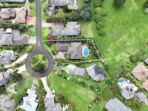 Vue aérienne d’un quartier résidentiel avec des maisons, une allée circulaire et une piscine.