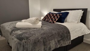 A neatly made bed with a grey blanket, white pillows, and a patterned pillow. - Balcony View Apartment- Sleeps 5 & Private Parking (Solihull)