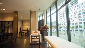 A modern hotel lobby with a large window, a bench, and a table with a plant. - Hotel MoMc (Beijing)