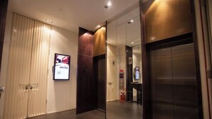 A modern elevator with a metallic finish and a glass panel. - Hotel MoMc (Beijing)