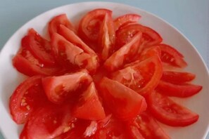 A white plate with neatly arranged tomato slices. - Juban Hotel (Hefei Yaohai Wanda Station Tang Subway Station Store) (Hefei)
