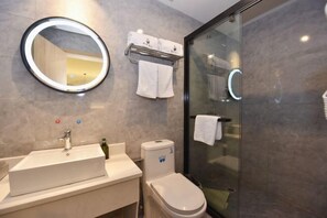 A modern bathroom with a large mirror, a sink, a toilet, and a glass shower enclosure. - Juban Hotel (Hefei Yaohai Wanda Station Tang Subway Station Store) (Hefei)