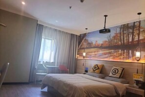A hotel room with a bed, a desk, a chair, a window with curtains, and a wall-mounted projector. - Juban Hotel (Hefei Yaohai Wanda Station Tang Subway Station Store) (Hefei)