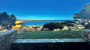 A stone bench overlooking a coastal landscape with a clear view of the sea and distant hills. - Residence in Stintino 50 mt from the sea (Stintino)