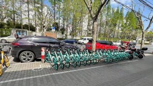 Un estacionamiento con varios coches y bicicletas.