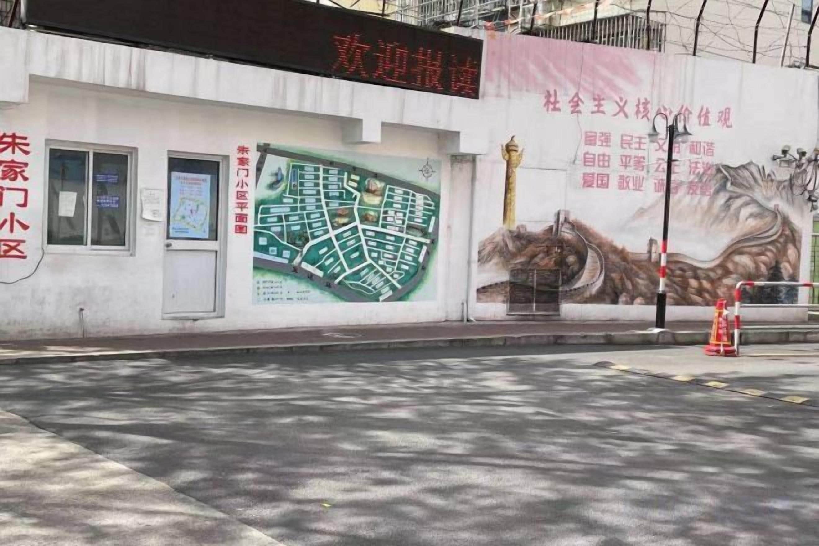 Fachada de edificio con un mapa, un letrero y un mural.