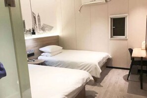 A hotel room with two beds, a small table, a chair, a window, and an air conditioning unit. - 99 Inn Preferred Hotel (Shanghai Wulian Road Subway Station) (Shanghai)