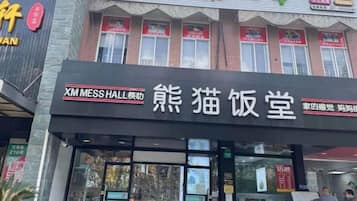 A storefront with a sign for XM Mess Hall and another for a cat cafe.