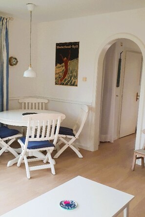 Enjoy meals in this dining area with a round table and four chairs, surrounded by a pendant light and a decorative plate.