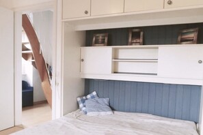 Cozy retreat with a comfortable bed and ample storage in a simple, functional space.