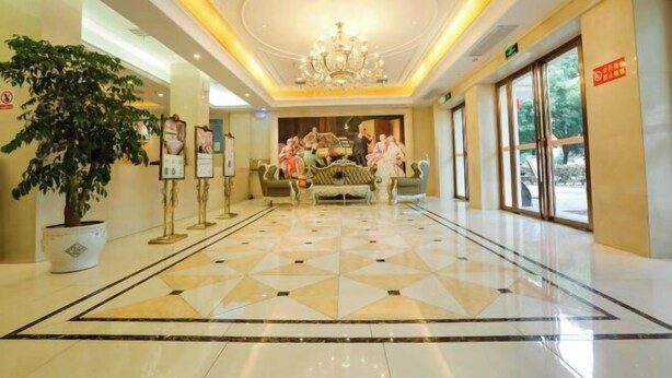 A hotel lobby with a chandelier, a large potted plant, and a seating area with sofas. - Vienna 3 Best Hotel (Jingmen Wanda) (Jingmen)