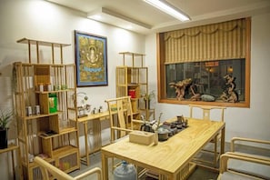 A dining area with a wooden table and chairs, surrounded by wooden shelves with various items. - Snowlake-Inn (Shangri-La)
