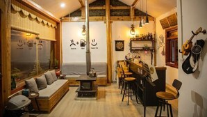 Un interior acogedor con sofá, zona de bar y chimenea.