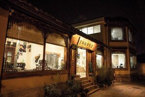 Un edificio tradicional con un letrero, ventanas y una escalera que lleva a la entrada.