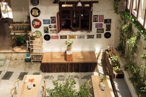 A cozy room with a wooden table, chairs, a small stage, and various wall decorations including posters and a clock. - Snowlake-Inn (Shangri-La)