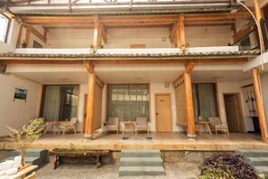 Un edificio tradicional japonés con un porche cubierto, pilares de madera y tatamis.