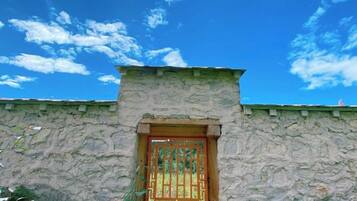 A stone building with a wooden door and a clear blue sky.
