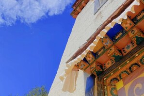 A building with traditional architectural elements, including ornate wooden carvings and a colorful facade. - Snowlake-Inn (Shangri-La)