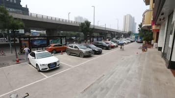 A parking lot with multiple cars and a pedestrian walkway.