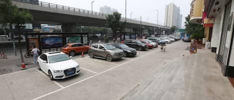 A parking lot with multiple cars and a pedestrian walkway.