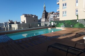 Relax by the rooftop pool with a stunning view of the historic building's iconic spire.