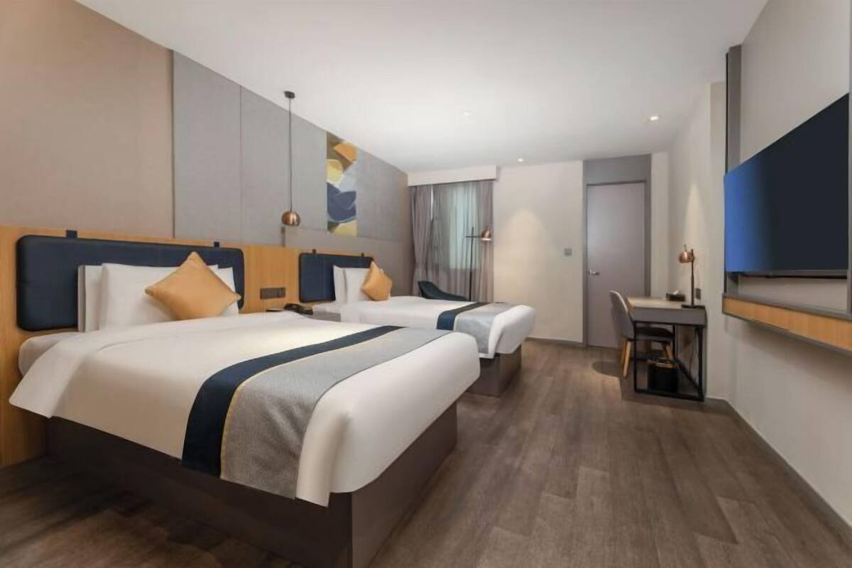 Una habitación de hotel con dos camas, un escritorio y una silla.