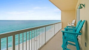 A balcony with a view of the ocean, a white railing, and two turquoise chairs. - Fall Deals + Snowbird Rates | Gulf Front Beach Escape (Panama City Beach)
