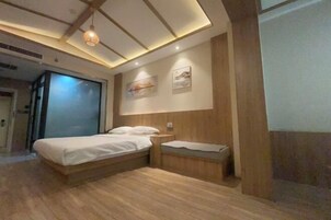 Un dormitorio moderno con una cama grande, cabecera de madera e iluminación empotrada en el techo.