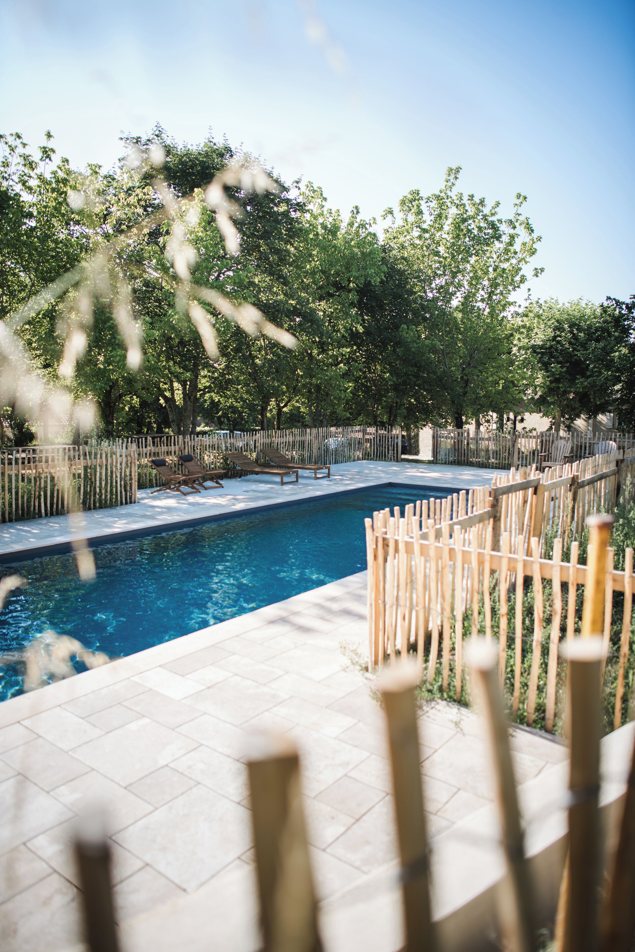Una piscina al aire libre de temporada, sombrillas