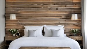 A bedroom with a wooden headboard, a large bed with white bedding, two bedside tables with lamps, and a wooden bench. - Domaine de Malet (Vitrac)