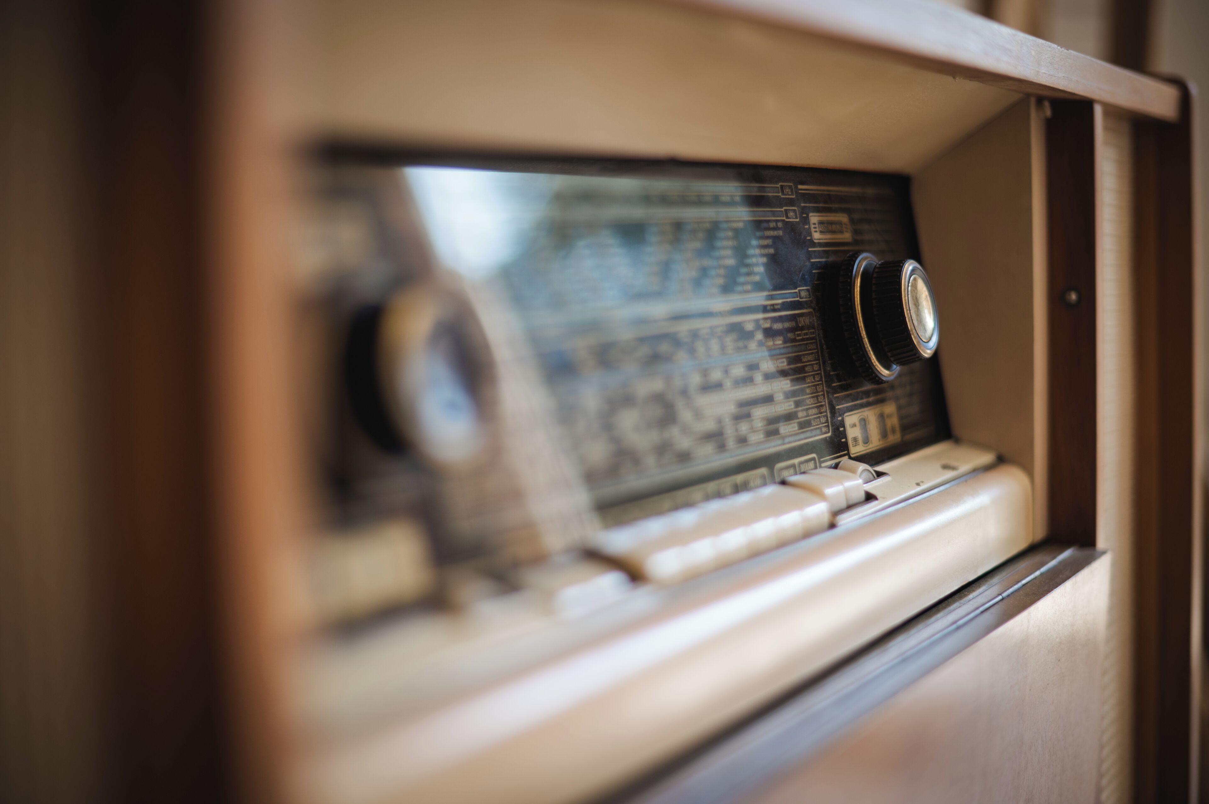 A vintage radio with dials and buttons, housed in a wooden cabinet.