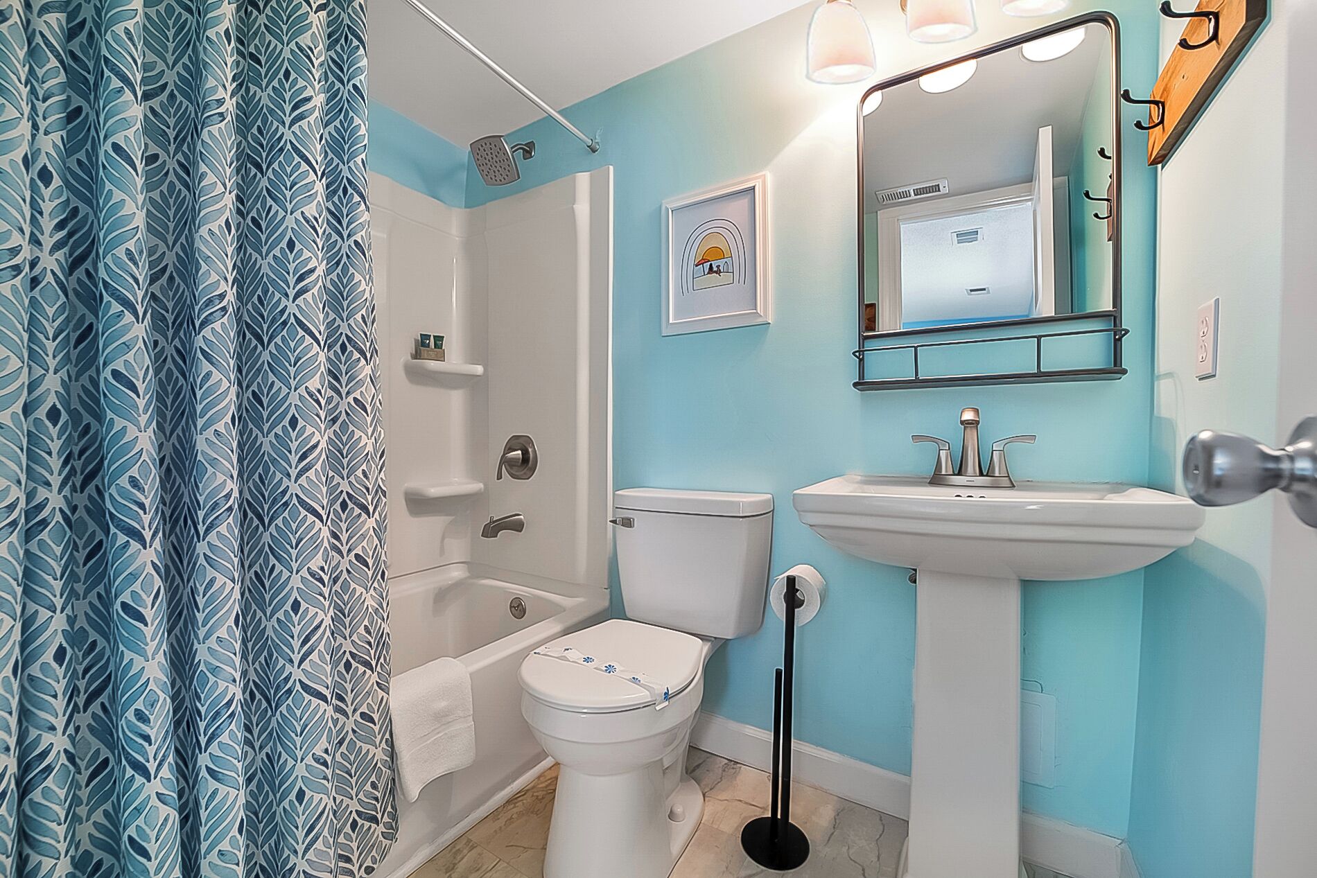 Een badkamer met bad, toilet, wastafel en douchegordijn.
